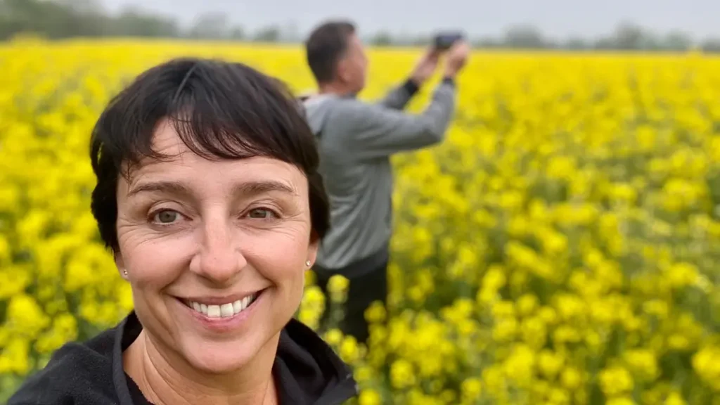 Woman in a field full of yellow flowers in England