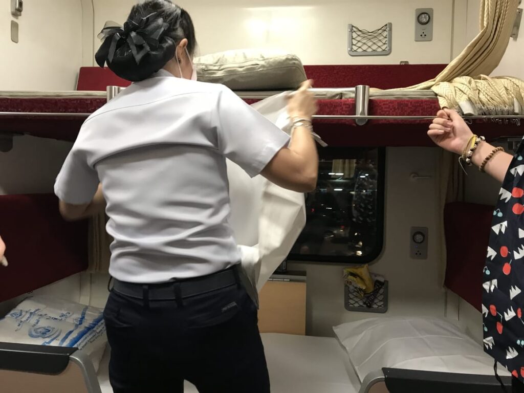 Thai woman making the beds up on the train from Bangkok to Chiang Mai