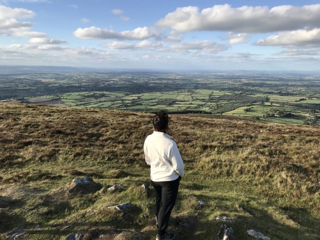 Woman on hillside in Ireland. Ireland travel tips for the perfect vacation