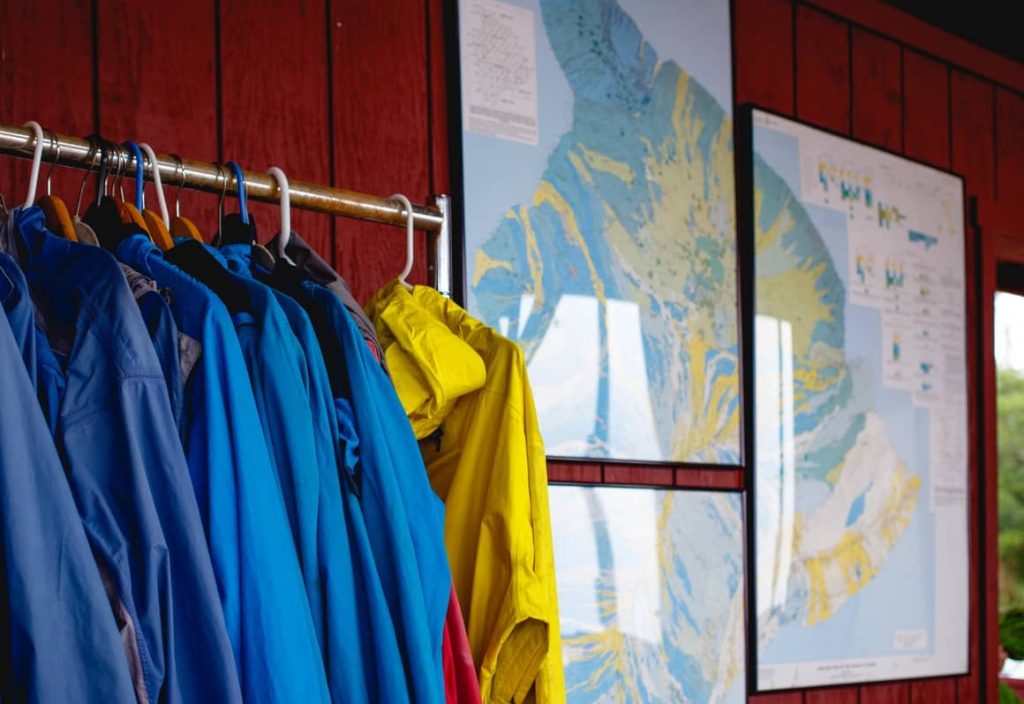 rain ponchos hanging up in front of a world map