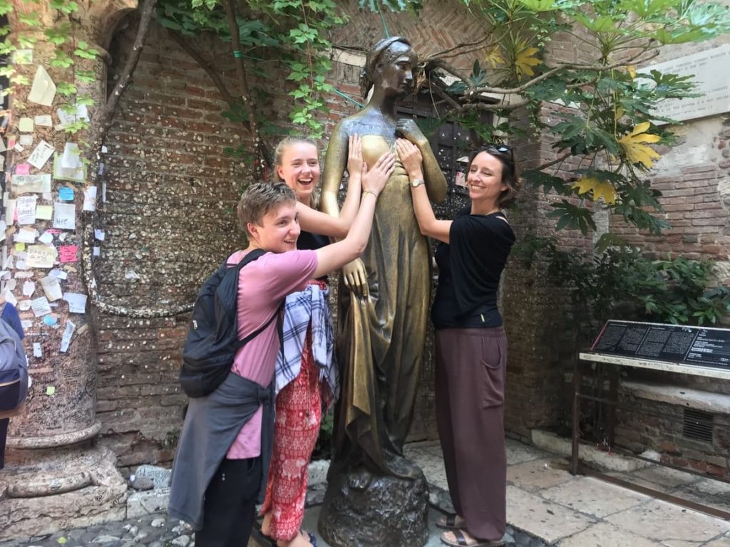 Tourists rubbing the statue of Juliet in Verona, Italy