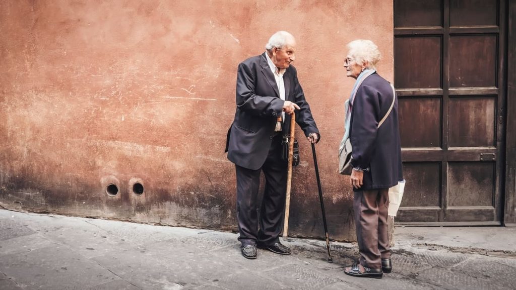 Two old people talking on the streets of Italy