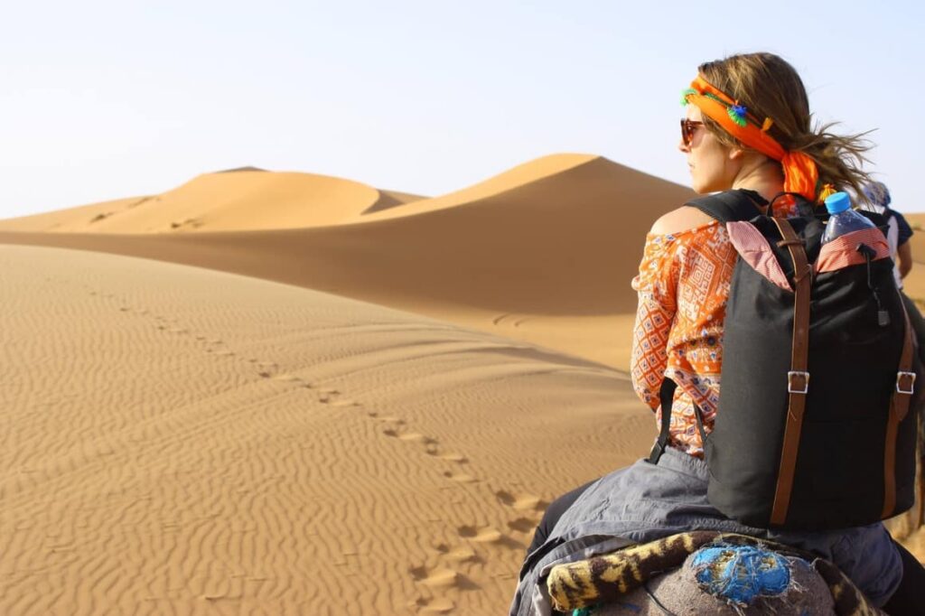 woman on a camel in the desert.Travel essentials