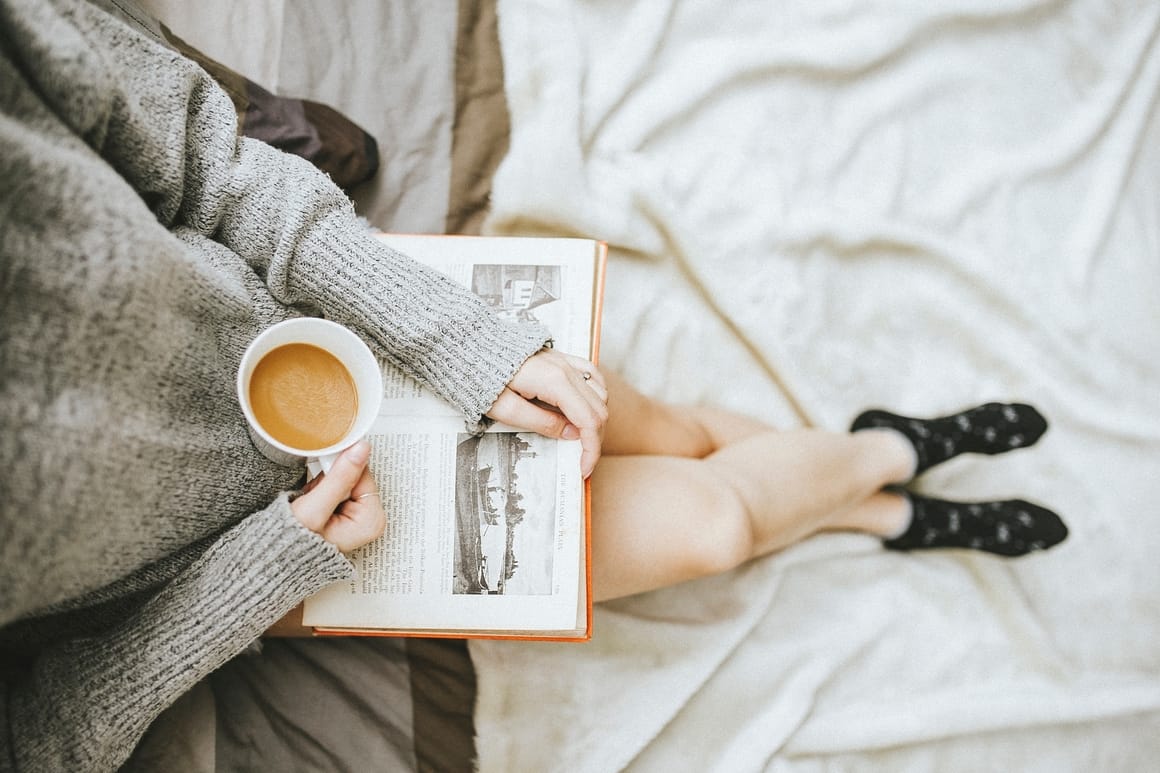 woman reading a book on the bed