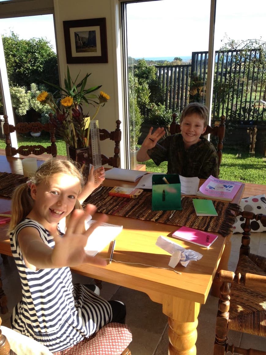 Kids homeschooling at a table.