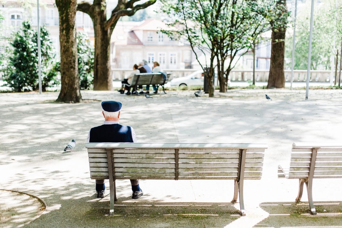 An old man sitting at a bench