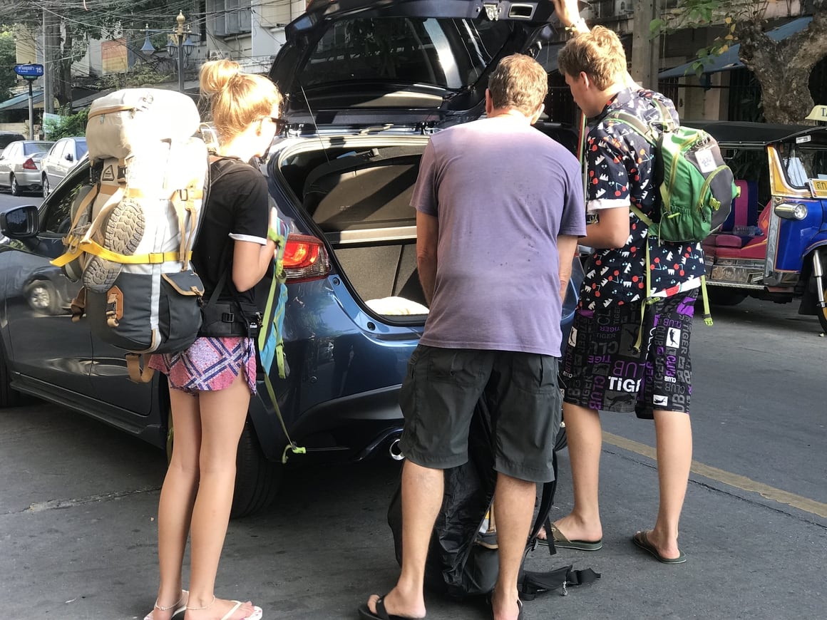 family packing into a car getting ready for a road trip