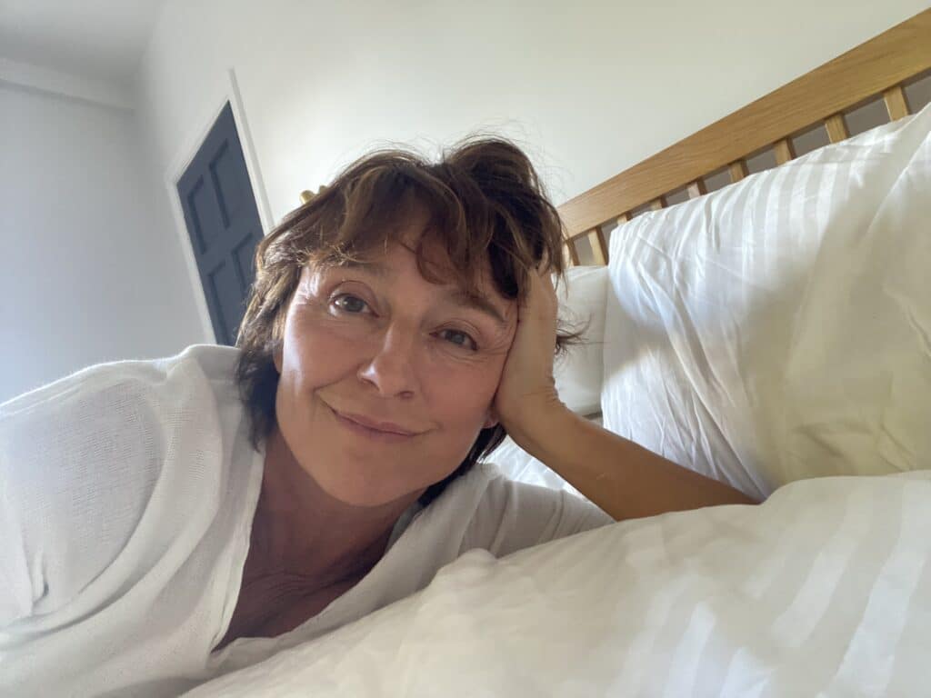 Author, Elizabeth Deacle on her bed looking at you after writing the book You won't Just cry When They Die. If you are struggling and hurting right now, please know you are not alone. I wrote this little book to be a gentle companion, to help you survive, cope, and begin to heal when your whole world falls apart.