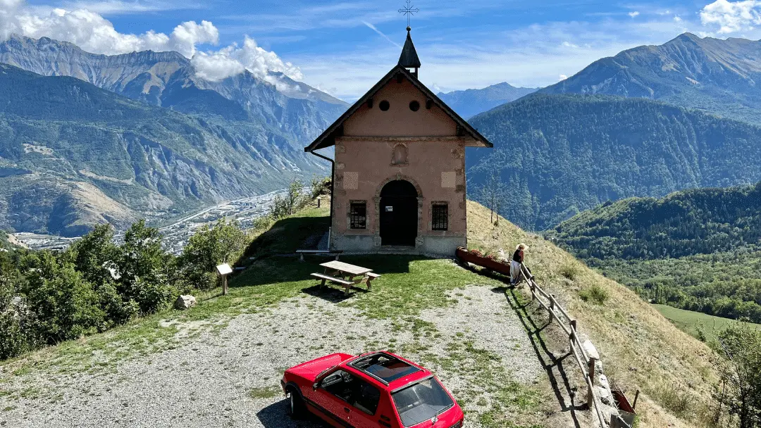 Little red car on the top of a beautiful mountain in France. It's a Drama podcast 