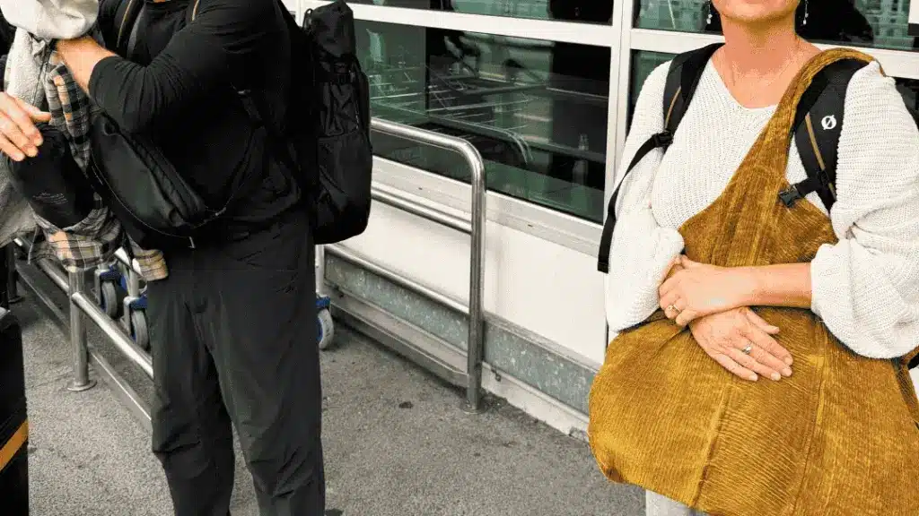 Woman carrying a big bag at an airport. Tips on how to sleep on a plane
