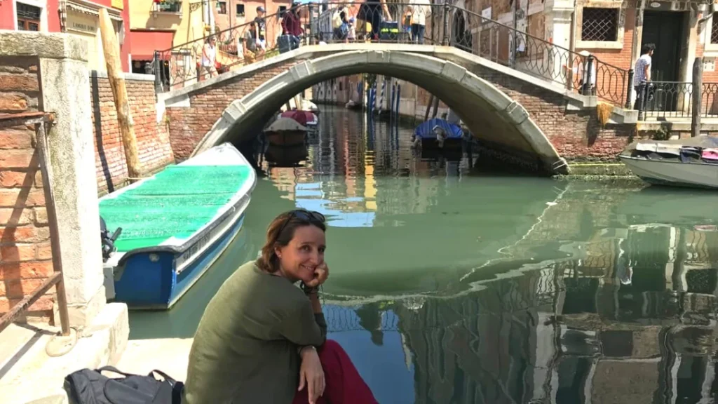 woman sitting beside the water in Venice. Things to do in Venice