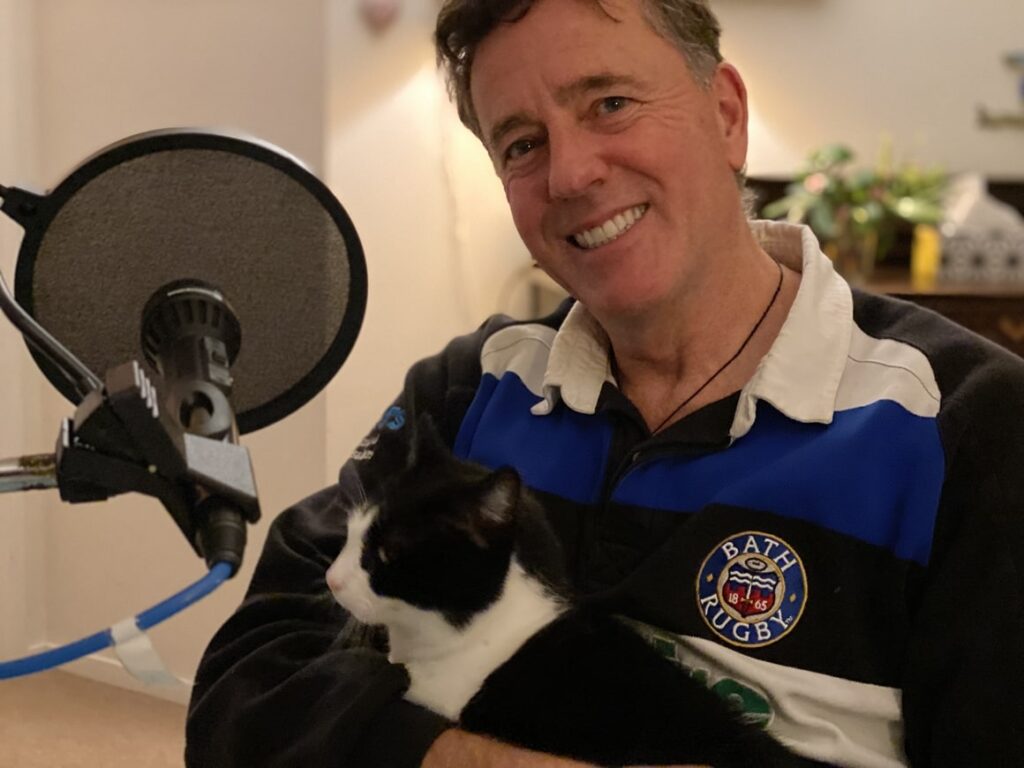 Man with a cat on his knee chatting on the new Zealand podcast