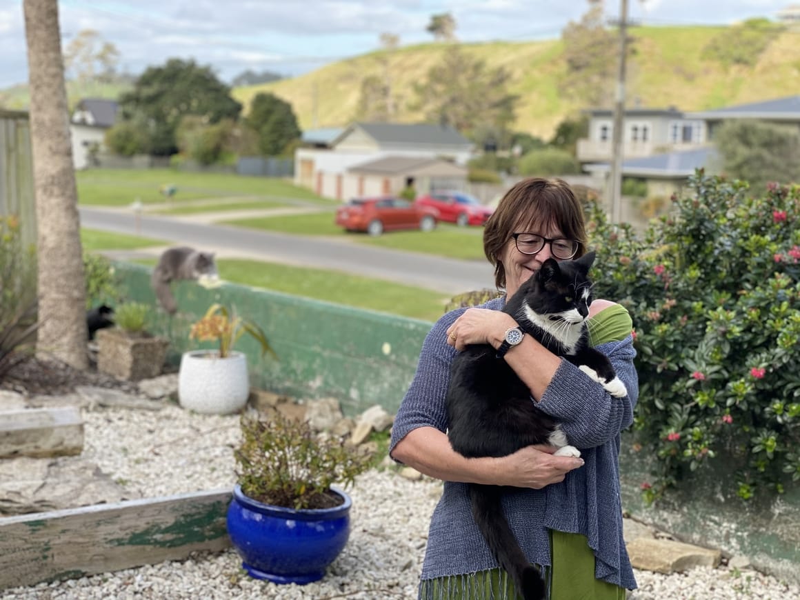 woman holding a cat in a garden