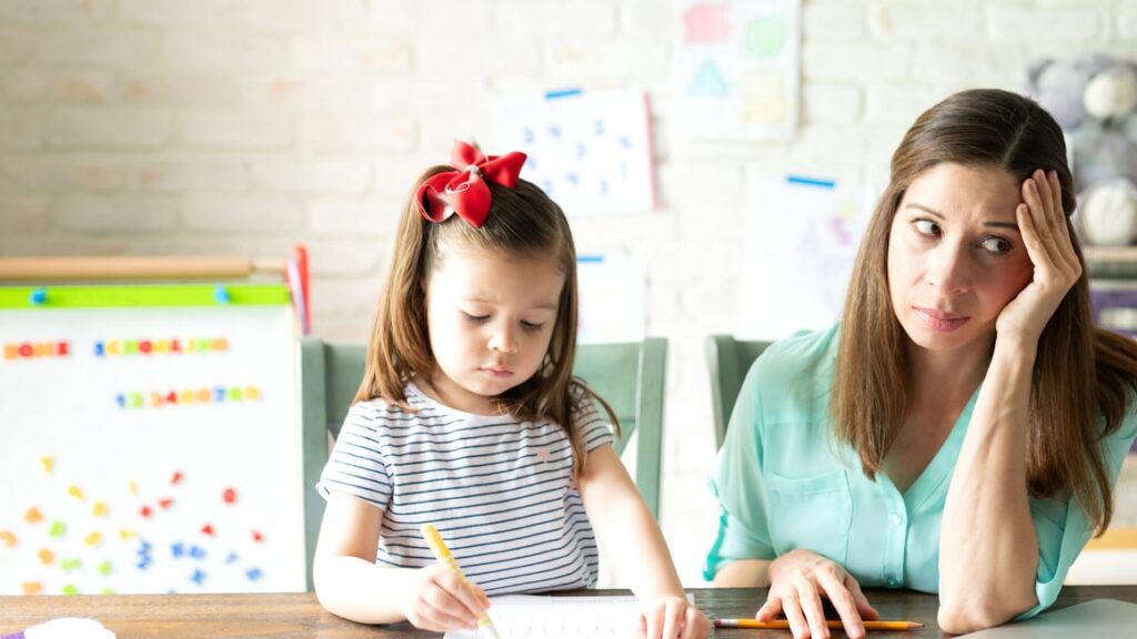 Woman looking stressed while teaching her daughter at home