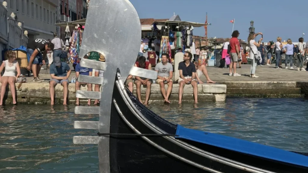 Tourists putting their feet in the water in Venice