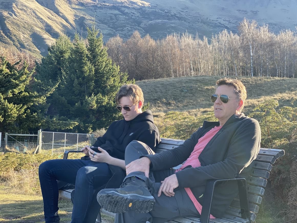 Boy and dad sitting on bench in New Zealand 