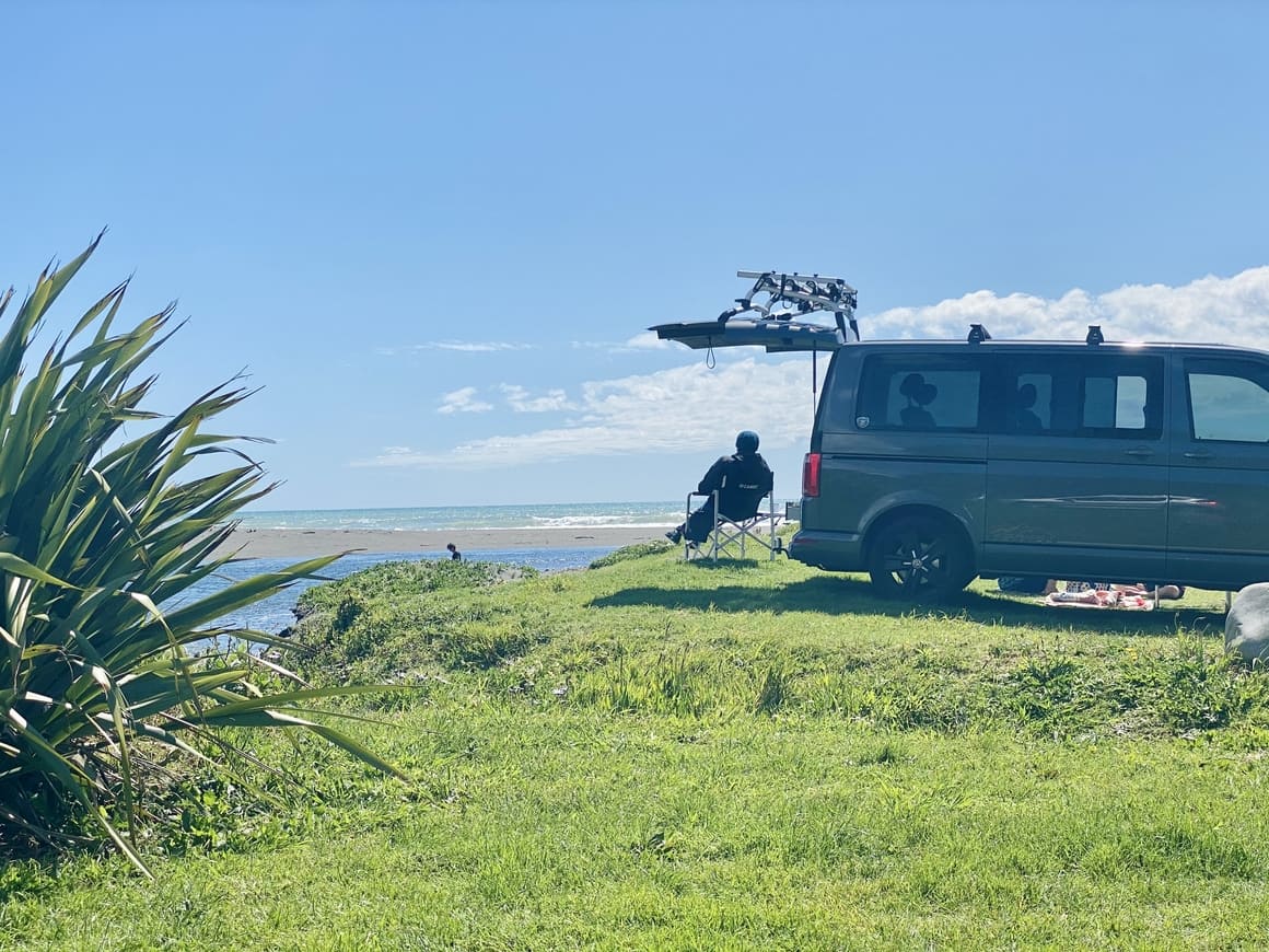 A woman sitting outside her motorhome in New Zealand