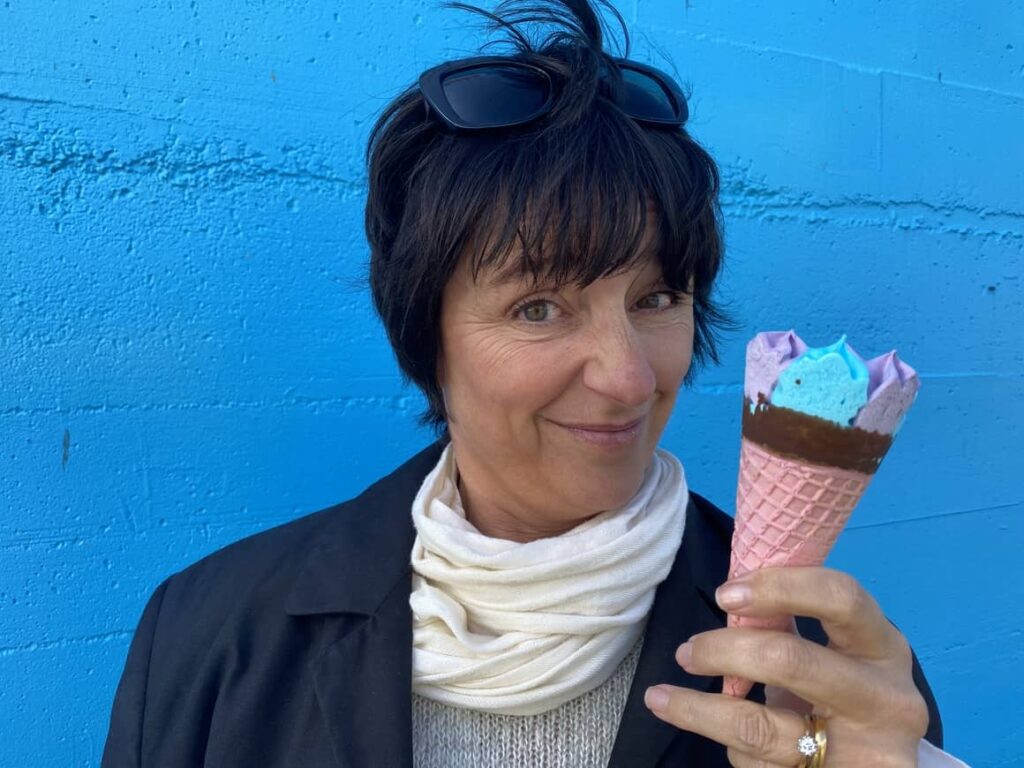 Woman holding an ice cream in New Zealand. Why is everything in New Zealand so expensive?