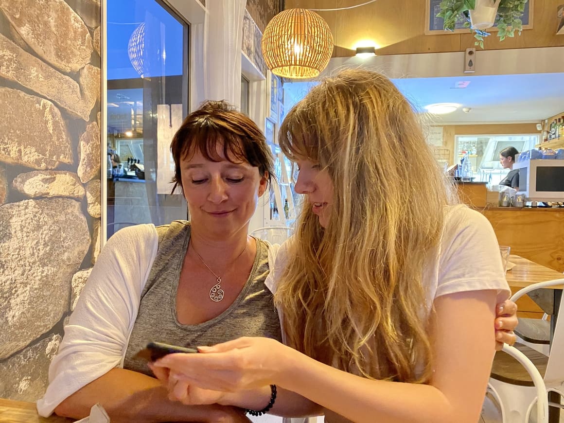 Girl showing her mum the phone.